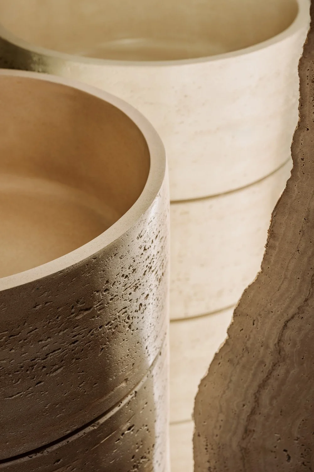 Close-up of a bespoke hand-finished travertine vessel basin showing raw stone texture and layered natural tones, designed by Limestone