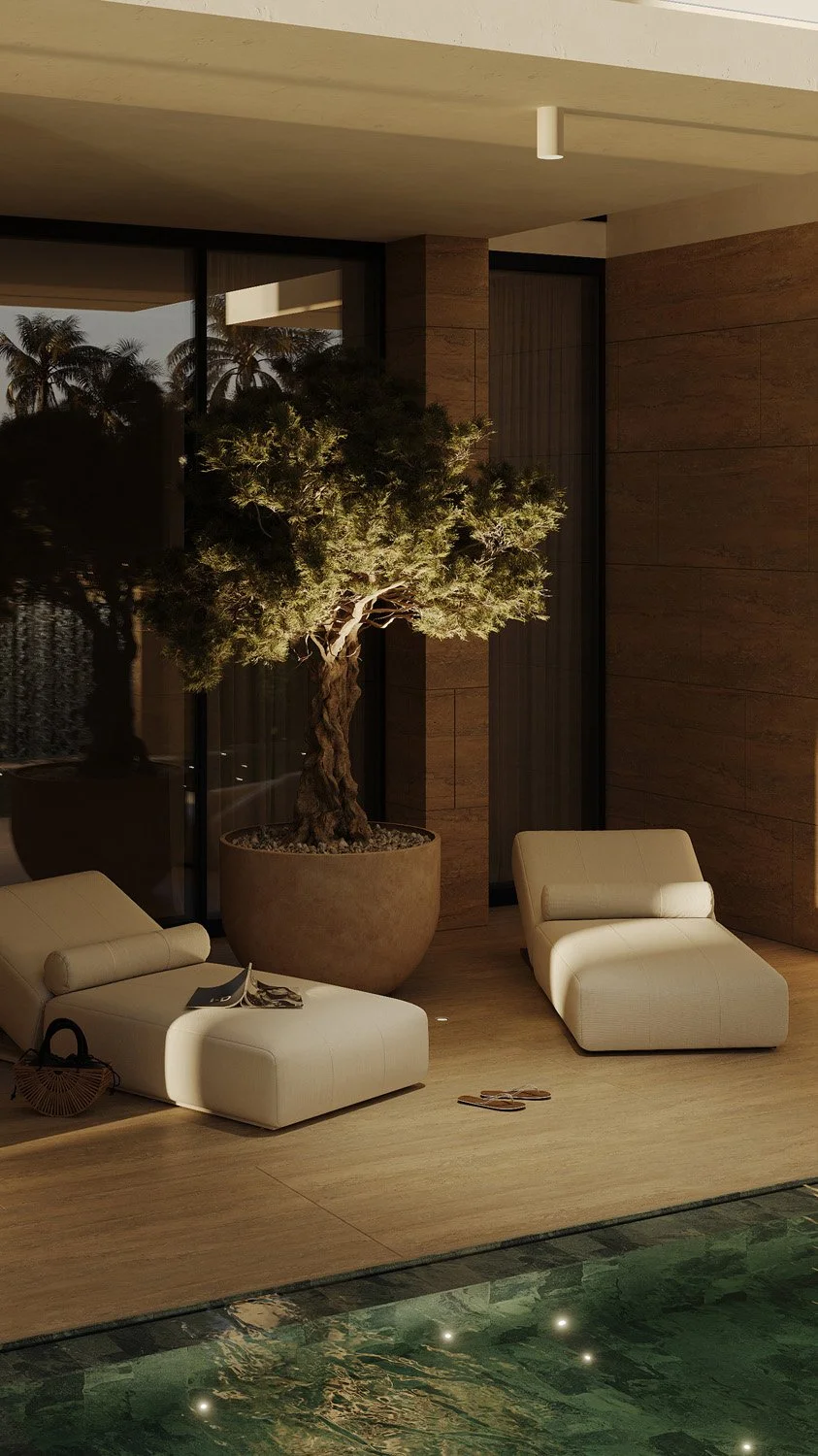 Evening view of the pool deck lounge in a Dubai Hills villa landscape, with cream chaise loungers and a sculptural olive tree in a terracotta planter, designed by Limestone
