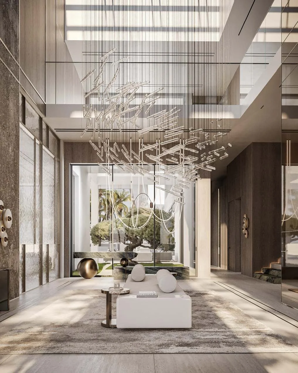 Modern hotel lobby with large glass windows, decorative hanging chandelier, and minimalistic white furniture with a patterned rug, opening to a garden with a tree.