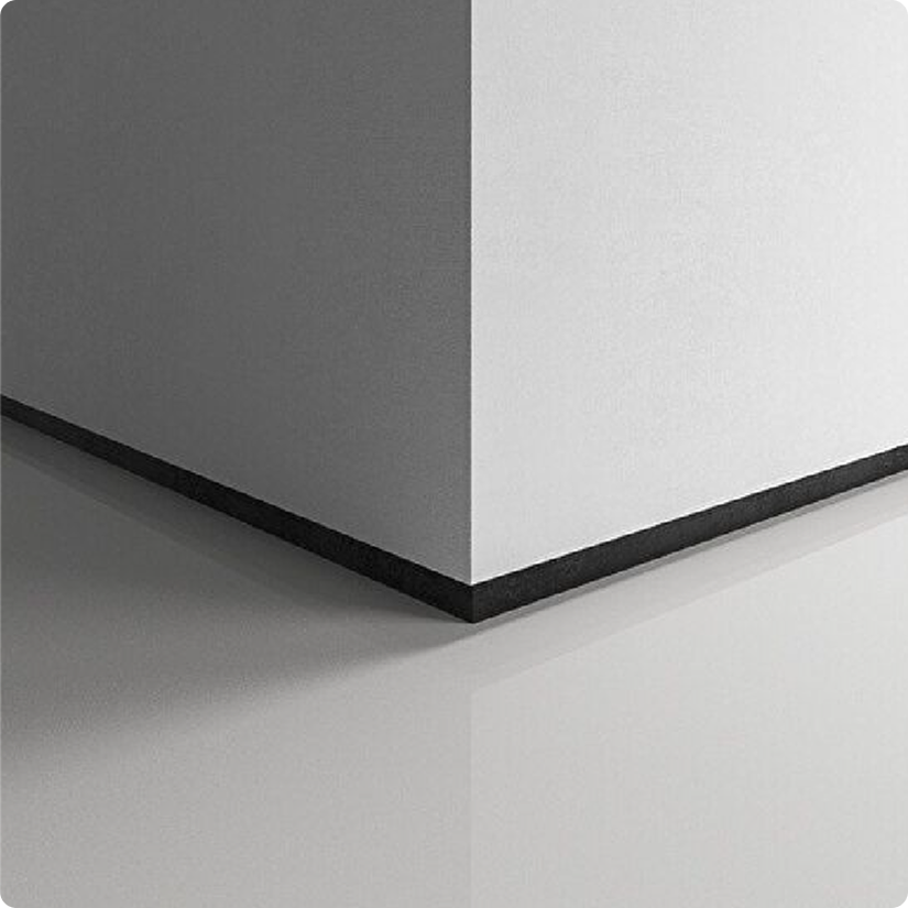 Close-up of the corner of a white board resting on a black base with a smooth surface.