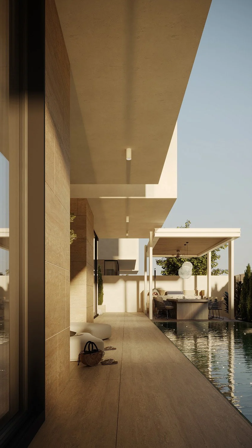 Pool walkway in a Dubai Hills villa landscape, leading toward the covered outdoor dining pavilion, with travertine paving and poolside lounge seating, designed by Limestone