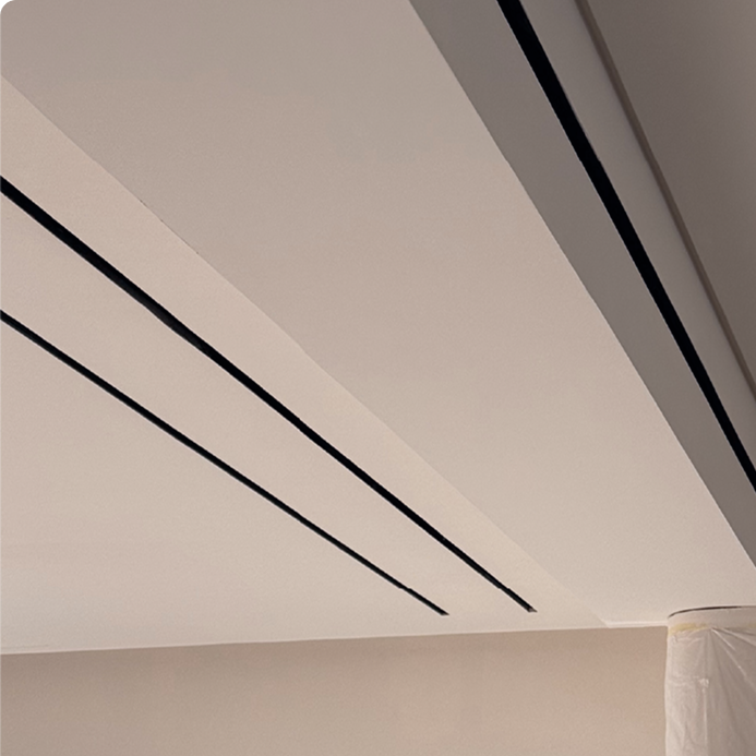 Limestone signature detail — 25mm AC diffusers disguised as lighting tracks and combined with matching-width light tracks for a seamless ceiling finish, luxury interior design Dubai