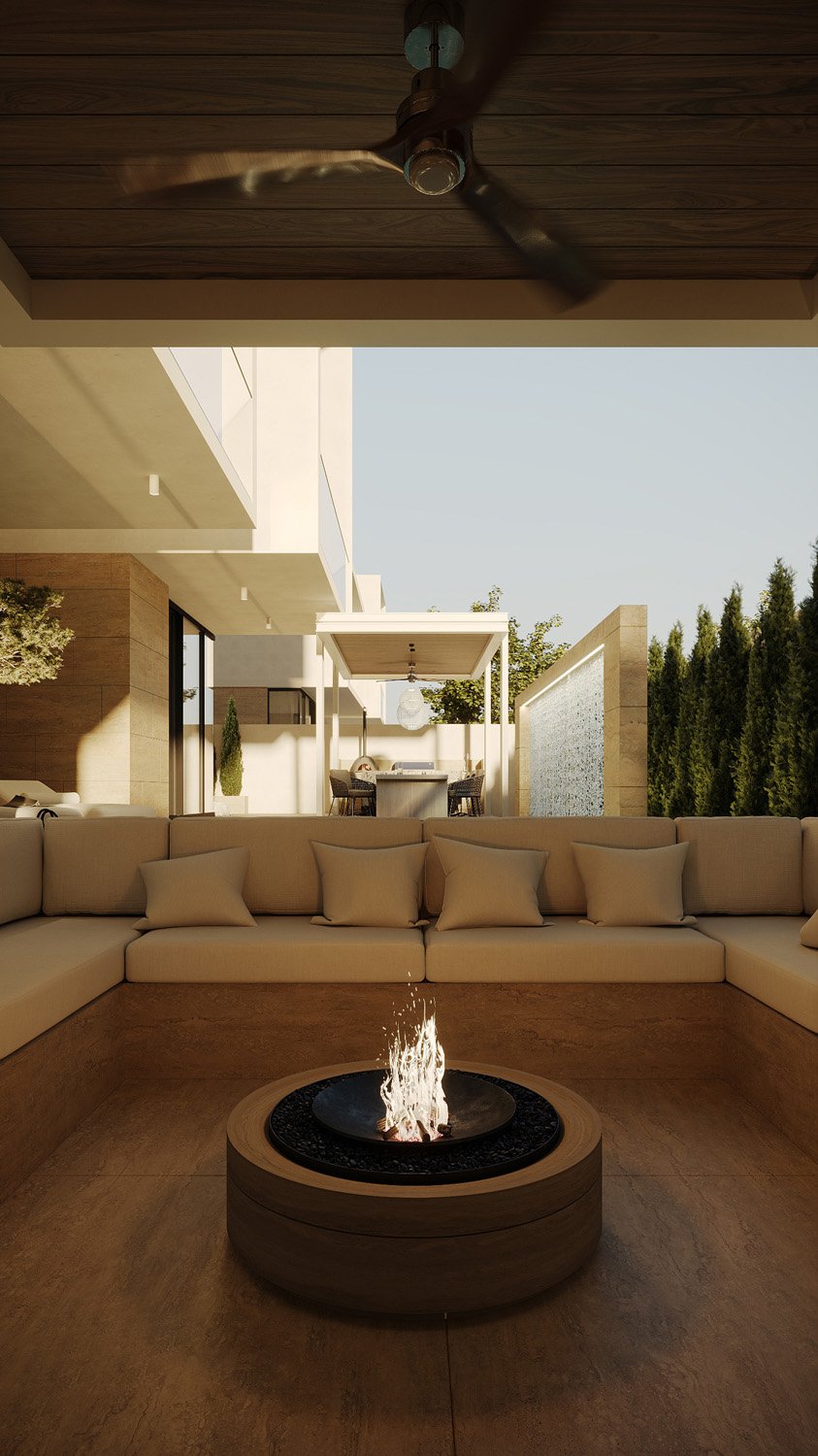 Sunken cinema seating area in a Dubai Hills villa landscape, with a built-in fire pit, wraparound upholstered bench, and views toward the outdoor dining pergola, designed by Limestone