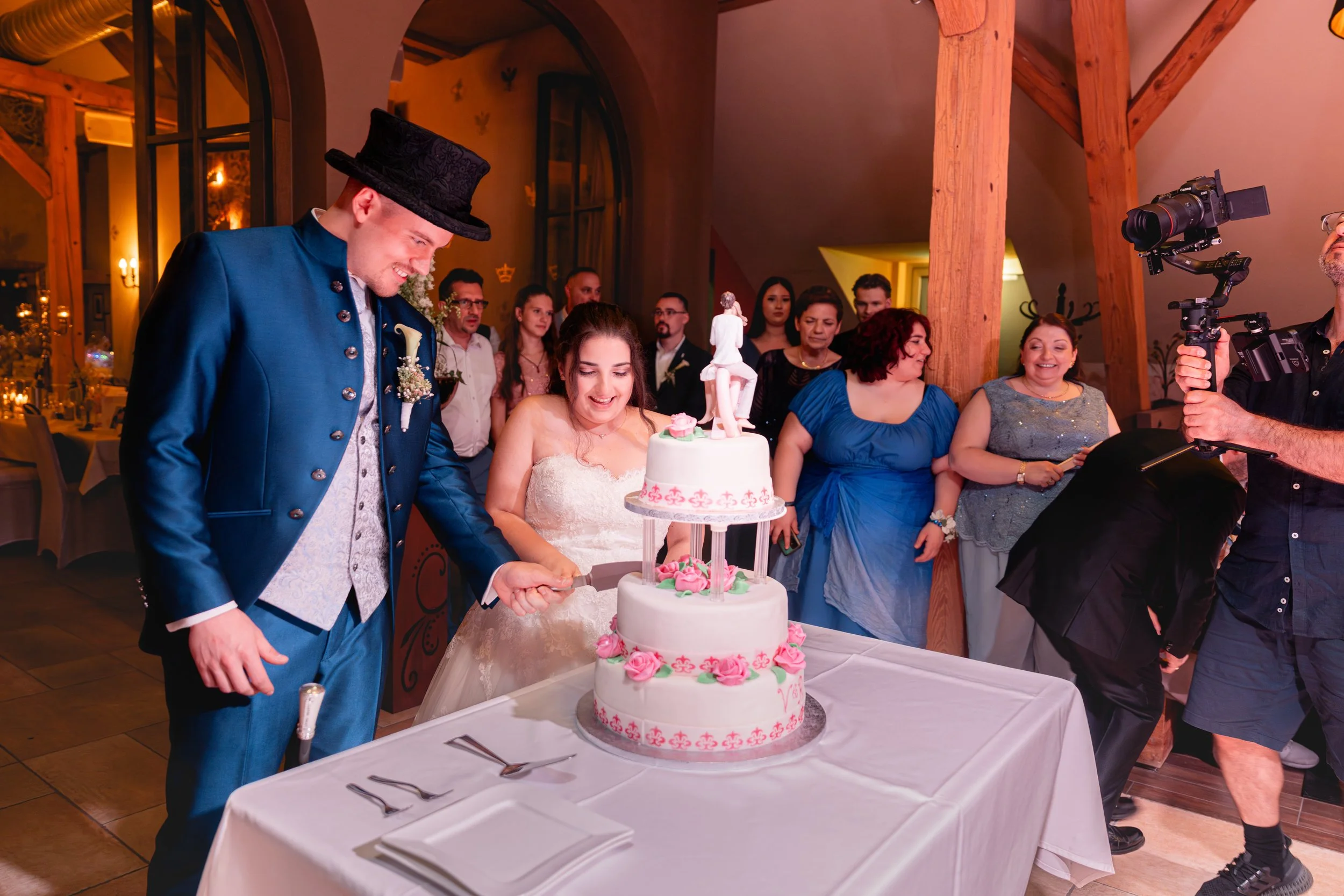 Ein Brautpaar beim Anschneiden der Hochzeitstorte