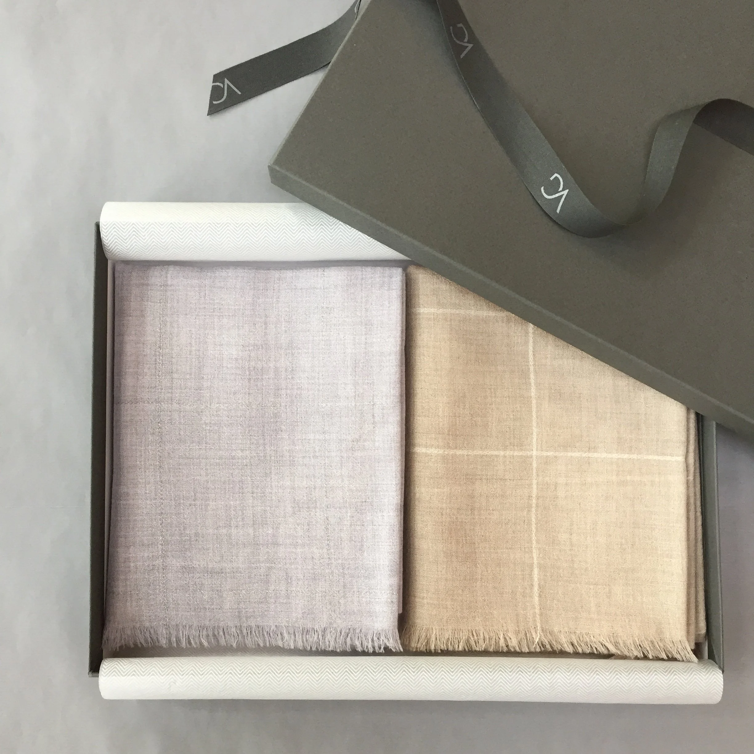 Trois tapis de différentes couleurs et textures empilés les uns sur les autres, déployés sur une surface plane.
