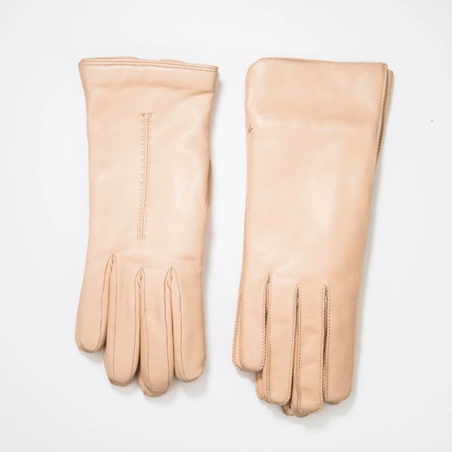 Une paire de gants en cuir beige posés sur fond blanc.