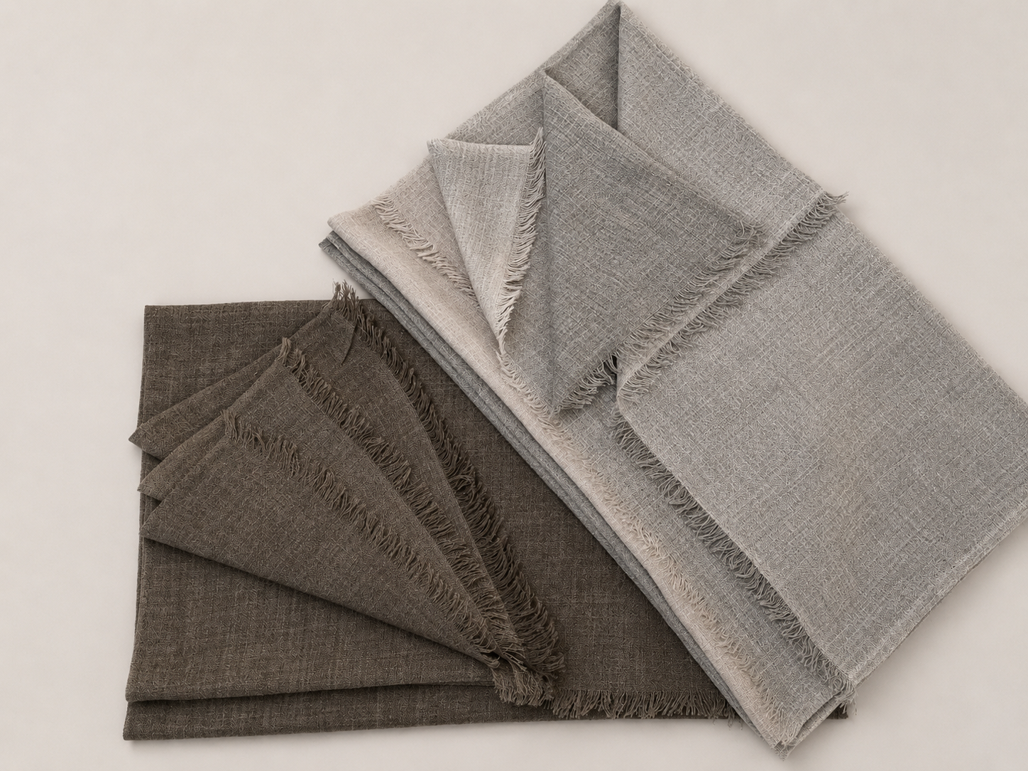 Tas de tissus en couleurs neutres avec franges, disposés en couches