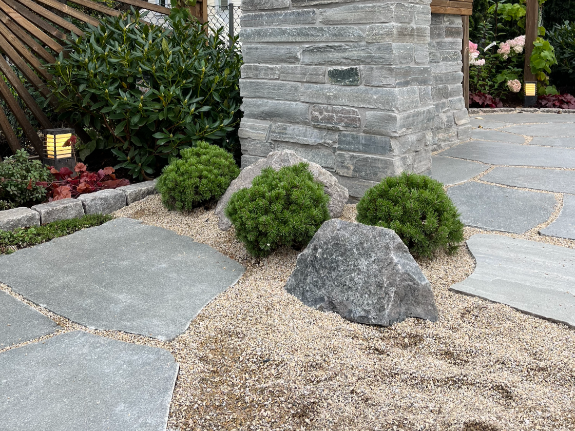 Detalj er fra prosjekt innen hagedesign. Zen-hagen er inspirert av japansk hagestil, der materialpaletten er hentet fra Skandinavia. Naturstein, stauder og furu.