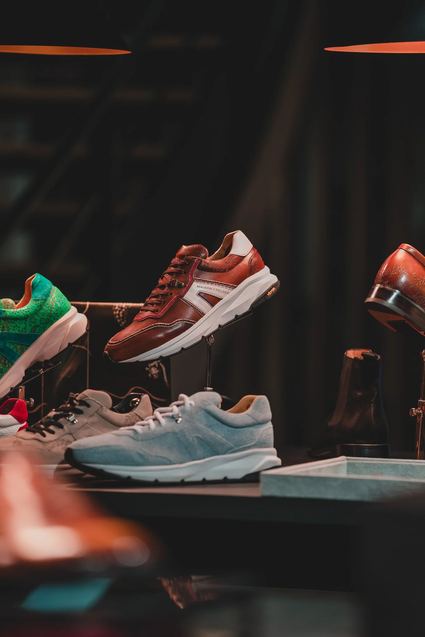 Différents modèles de chaussures affichés dans un magasin, avec des styles variés et des couleurs différentes.