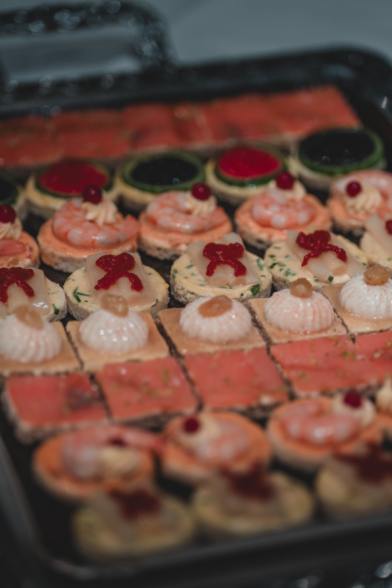 Plateau de canapés de Noël, avec des formes variées, décorés de crevettes, saumon, et autres garnitures festives