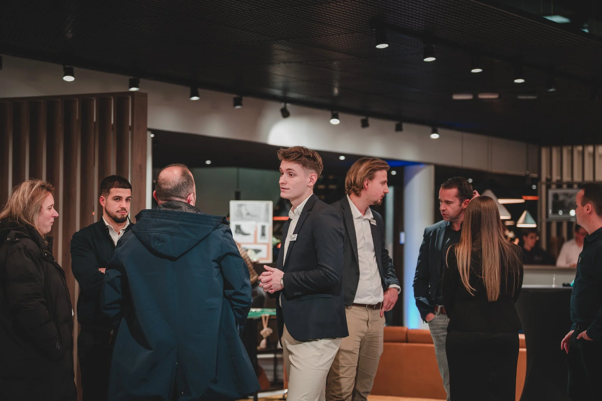 Groupe de personnes discutant dans un espace intérieur moderne.