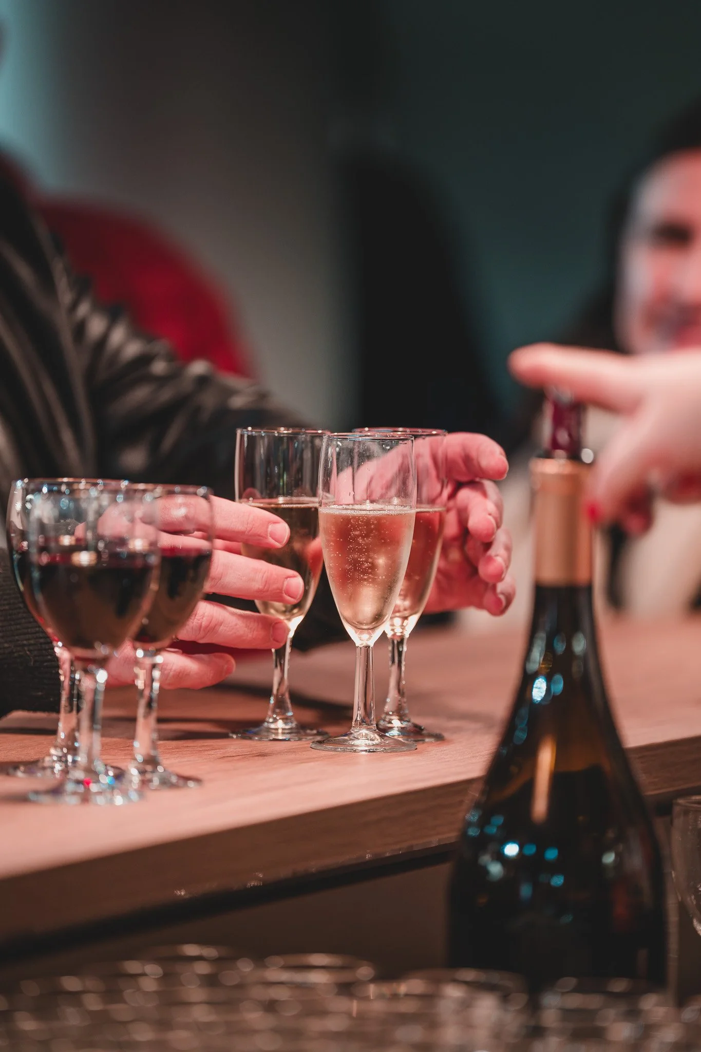 Groupe de personnes trinquant avec des verres de champagne et de vin dans un bar