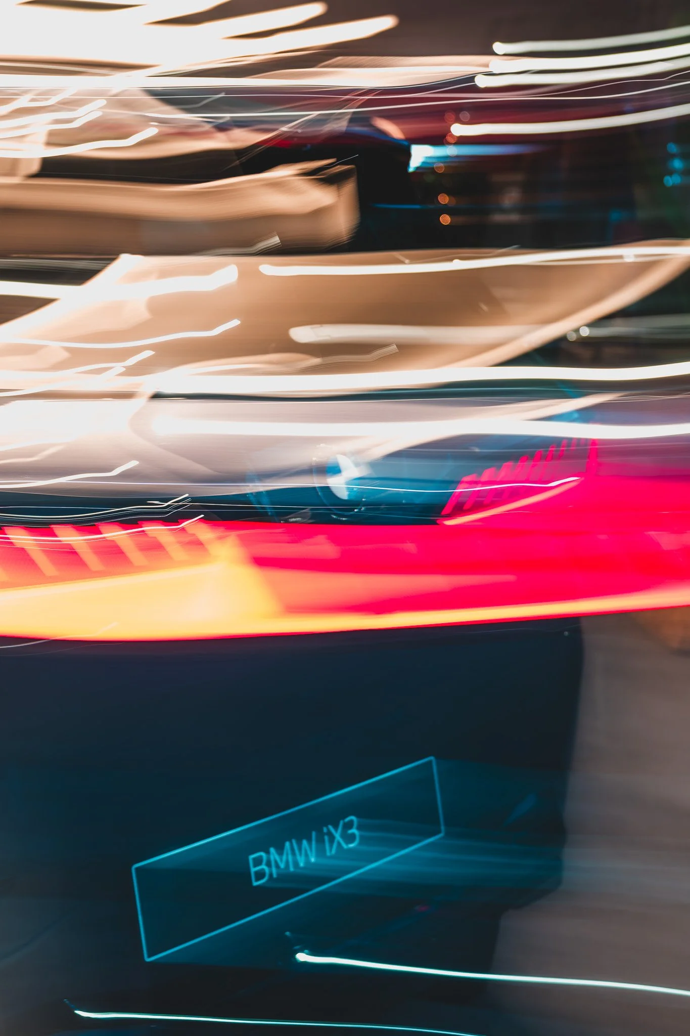 L'image montre un affichage numérique lumineux avec le texte 'BMW iX3', dans un contexte urbain à nuit, avec des lignes de lumière déformées et mouvement.