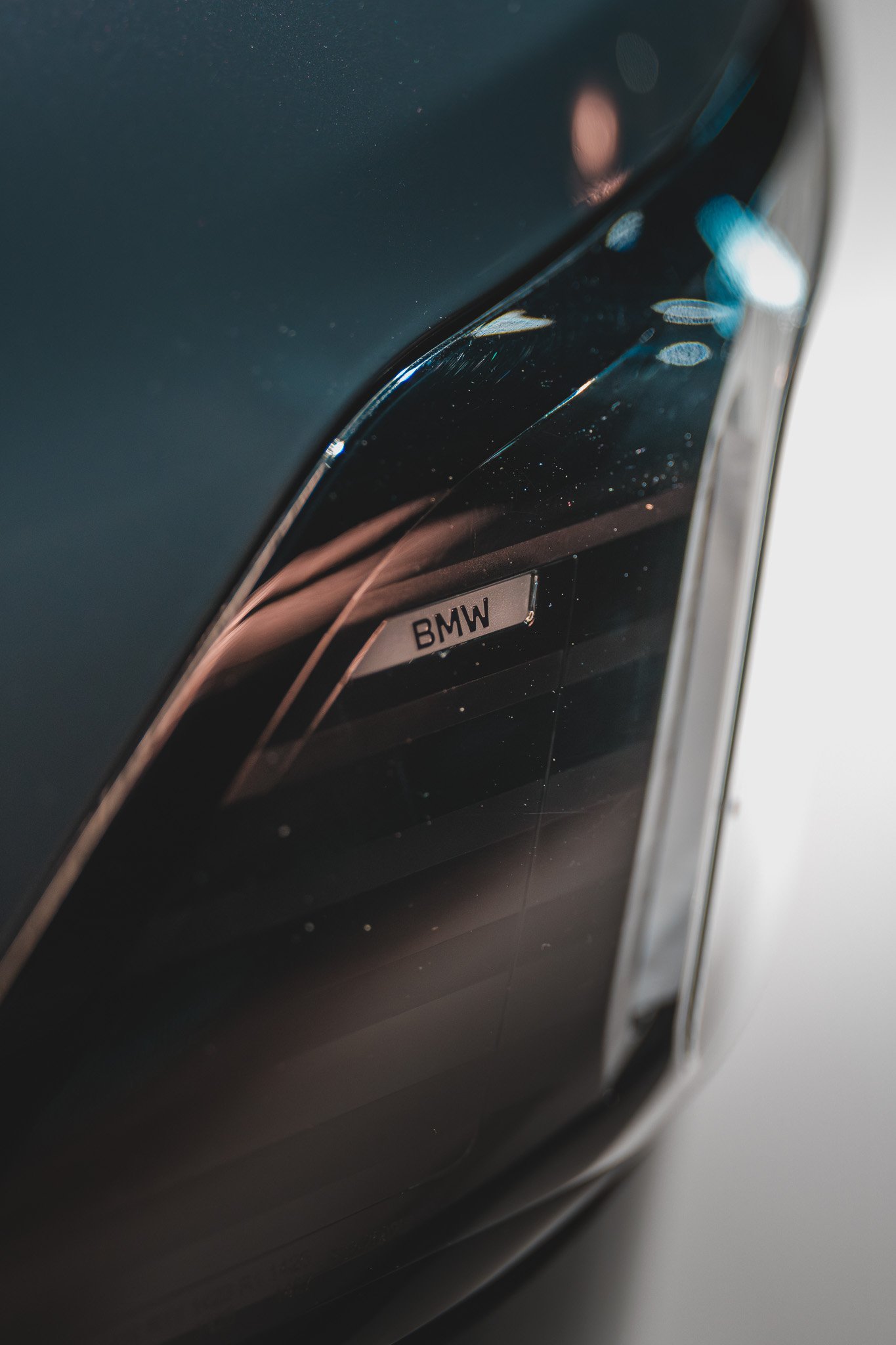 Détail d'une voiture BMW avec le logo visible sur une calandre noire, vue en gros plan.