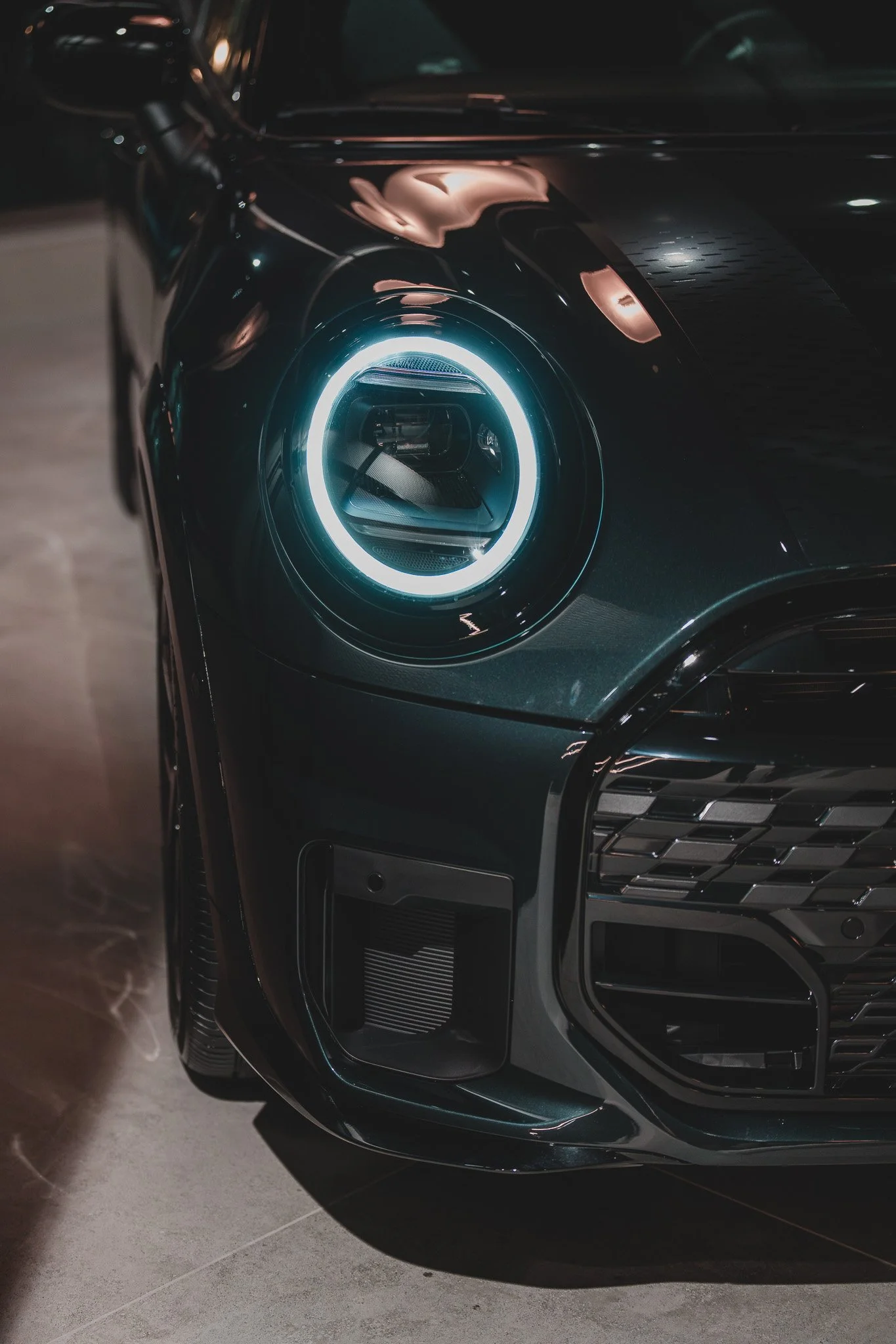 Un phare de voiture moderne, à LED, allumé, sur une voiture noire.