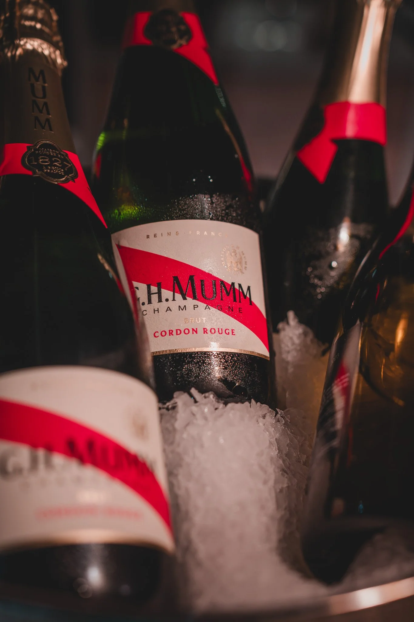 Bouteilles de champagne chauffée sur des glaçons, notamment une bouteille de C.H. MUMM Cordon Rouge.
