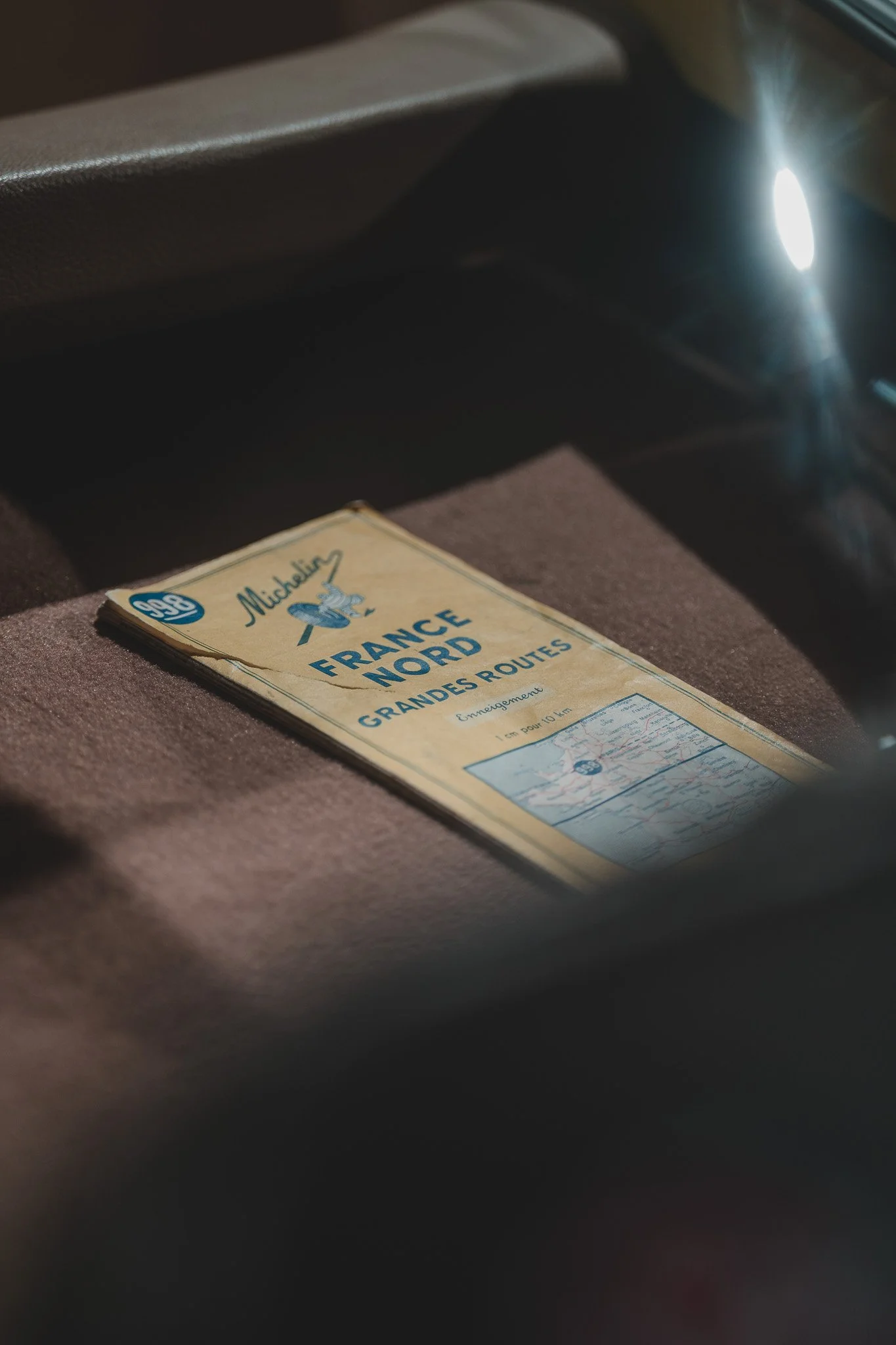 Un guide routier pour la région Nord-Est de la France, publié par Michelin, placé sur un siège de voiture.