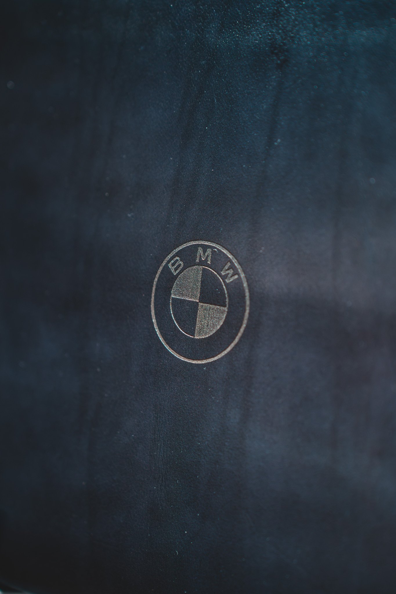 Photo rapprochée du logo BMW gravé sur une surface noire.