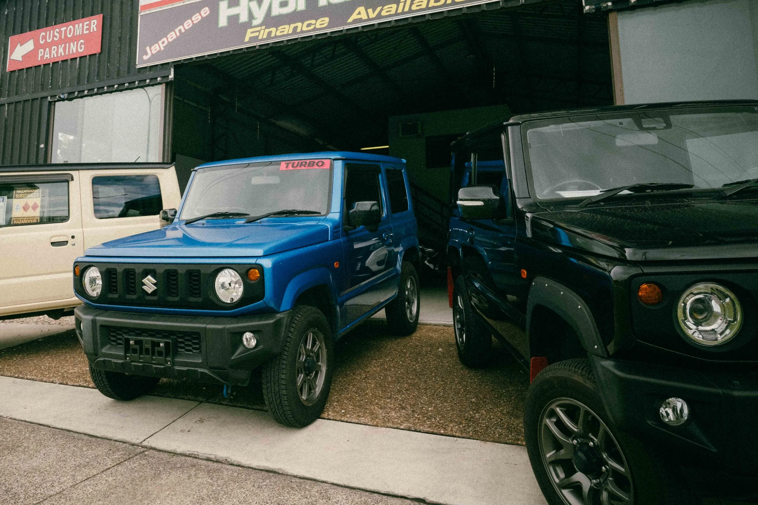 A black magnifying glass lying on a white surface partially covering a silver laptop.