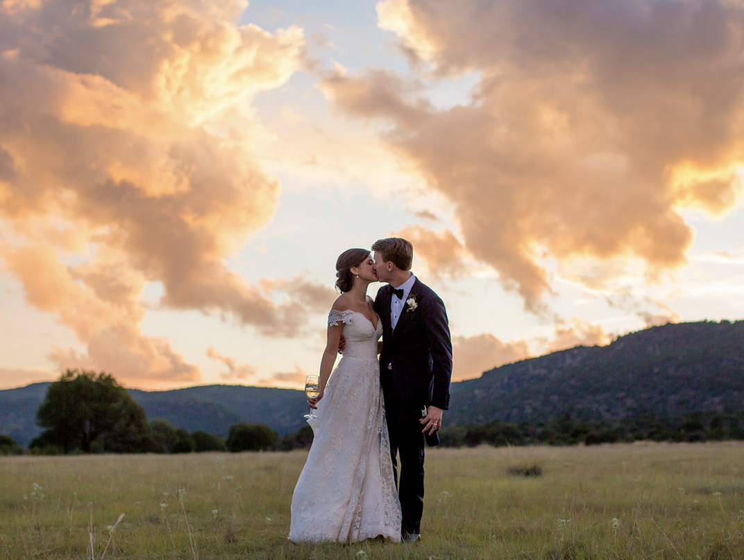bride and groom at sunset in a grassy field