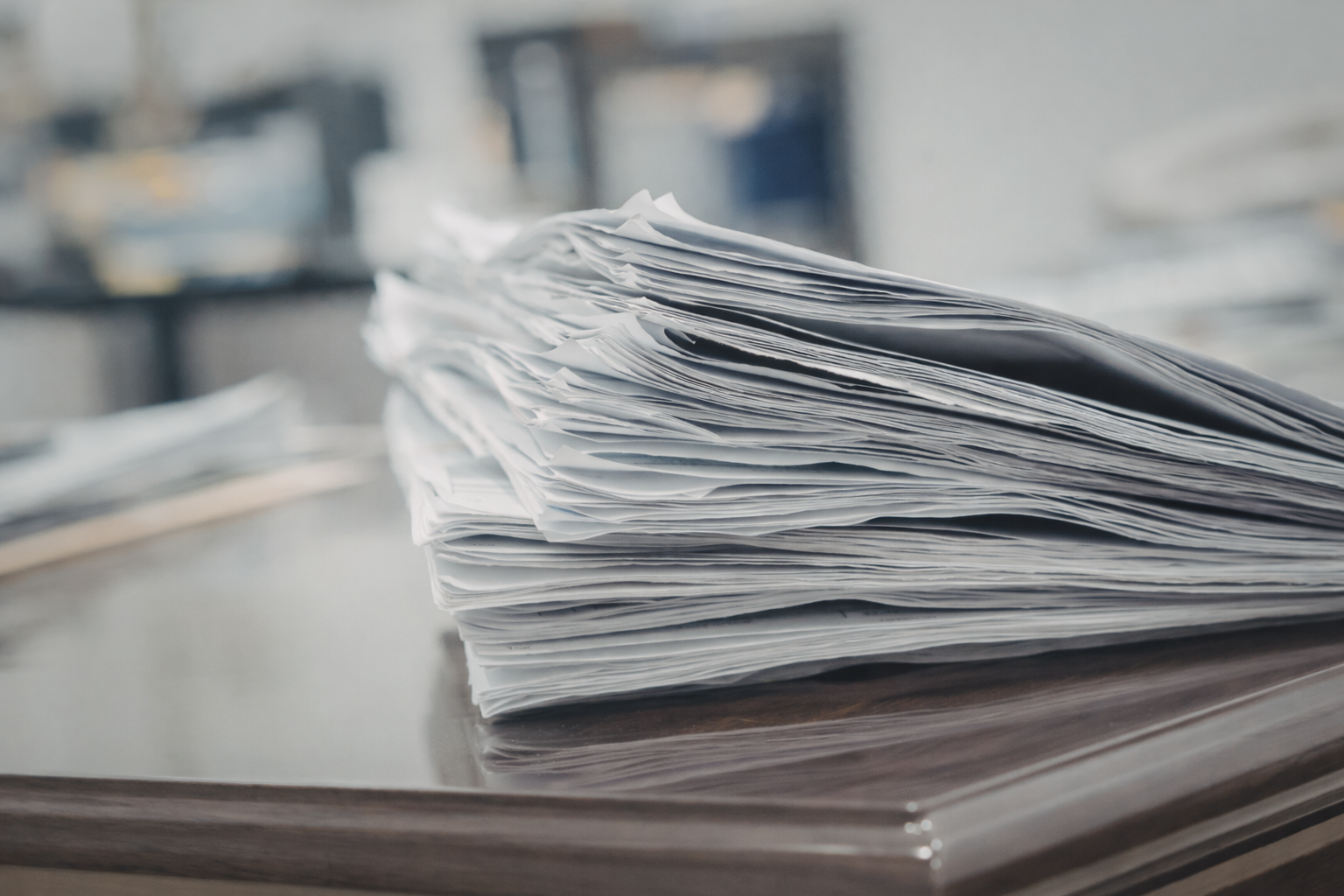 Junge sitzt auf einer Bank vor einer neutralen Wand, trägt graues Polohemd und beigen Hosen, Schatten im Hintergrund.