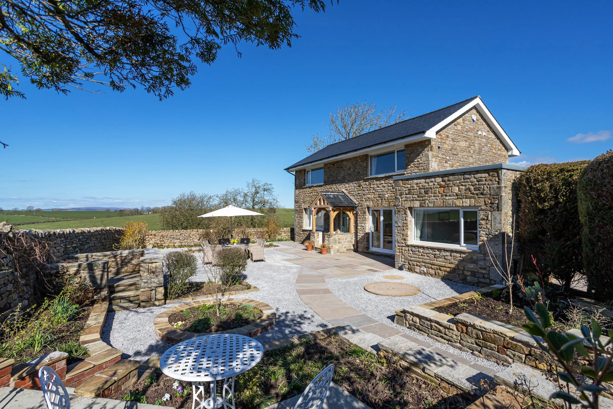 Path from car park up to front door/porch. Flat gravelled areas and patio. 