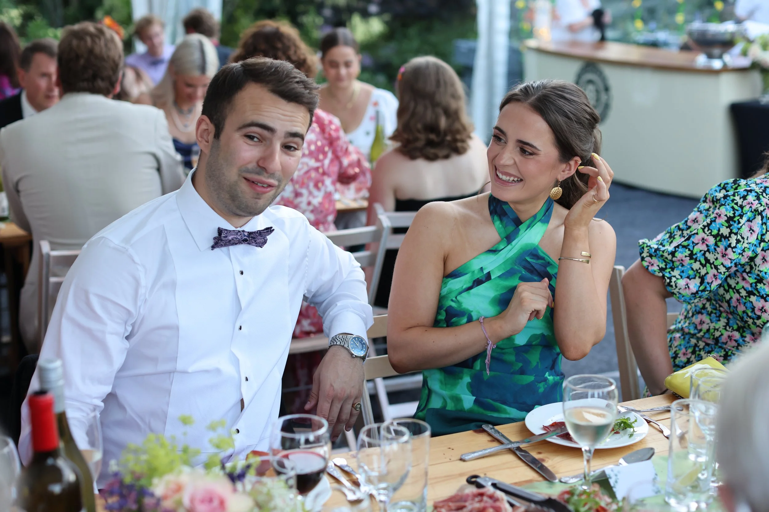 People at a joyful outdoor gathering enjoying food and drinks at a social event.