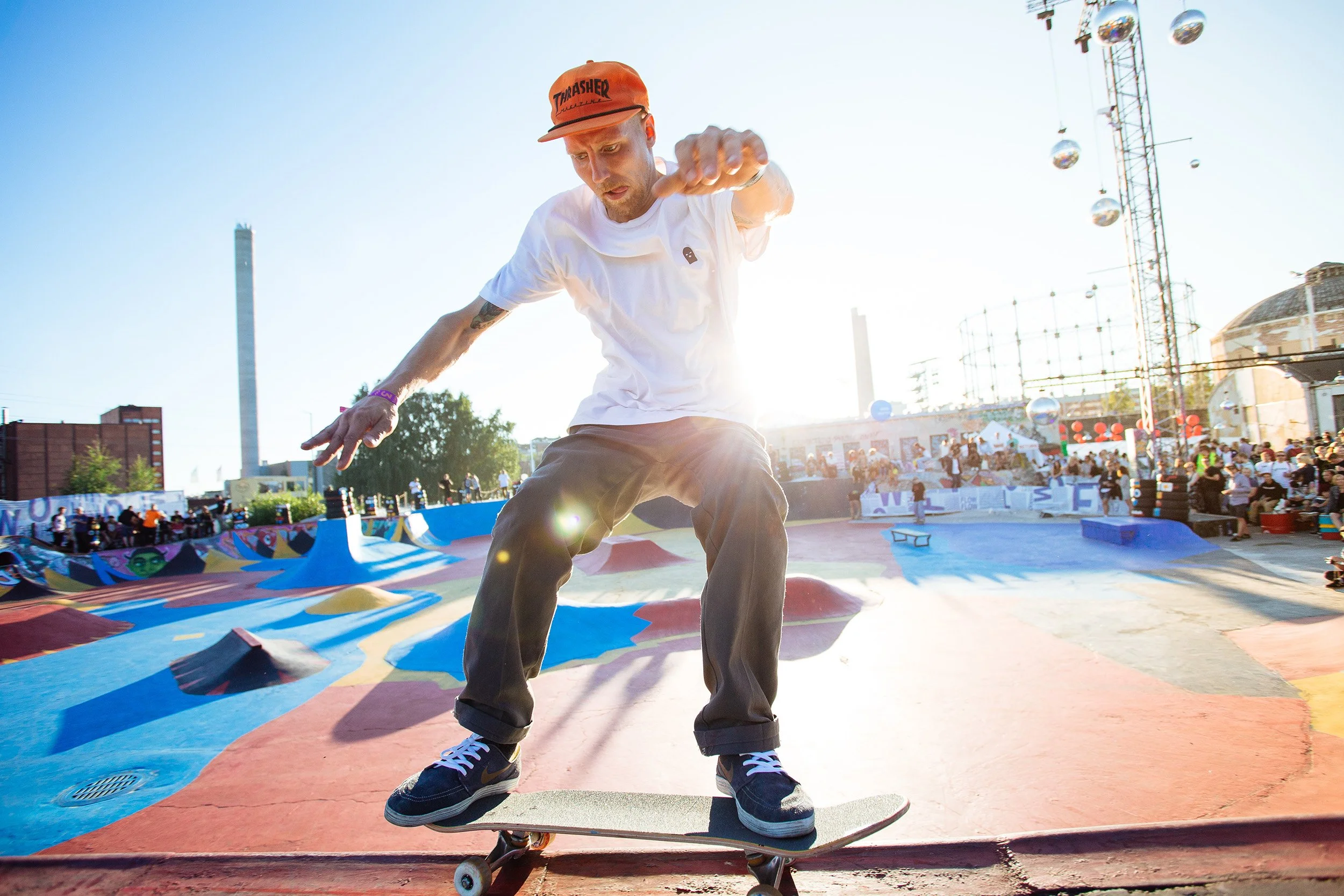 Nuori mies skeittilautailee skeittipuistossa auringon laskiessa.