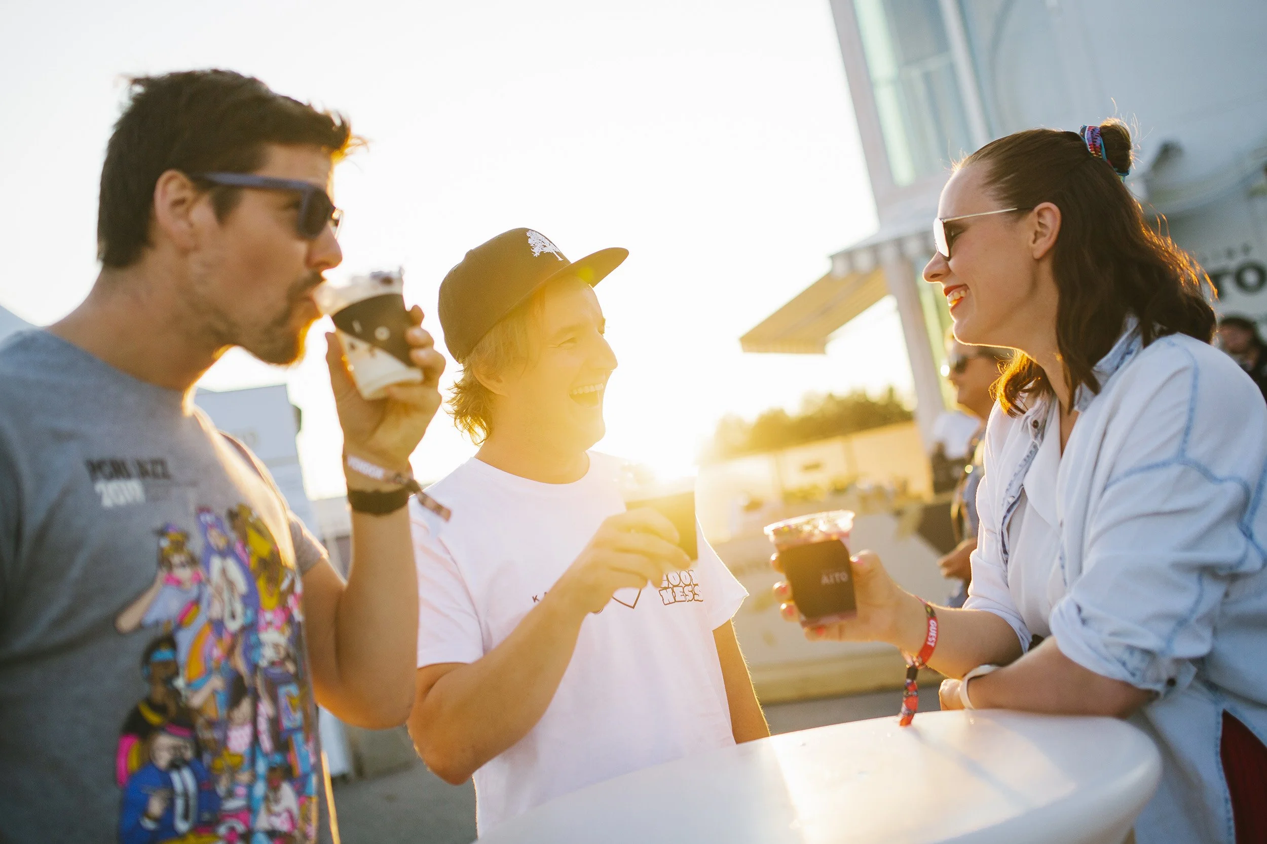 Kolme ihmistä nauttii jäätelöä ilta-auringossa.