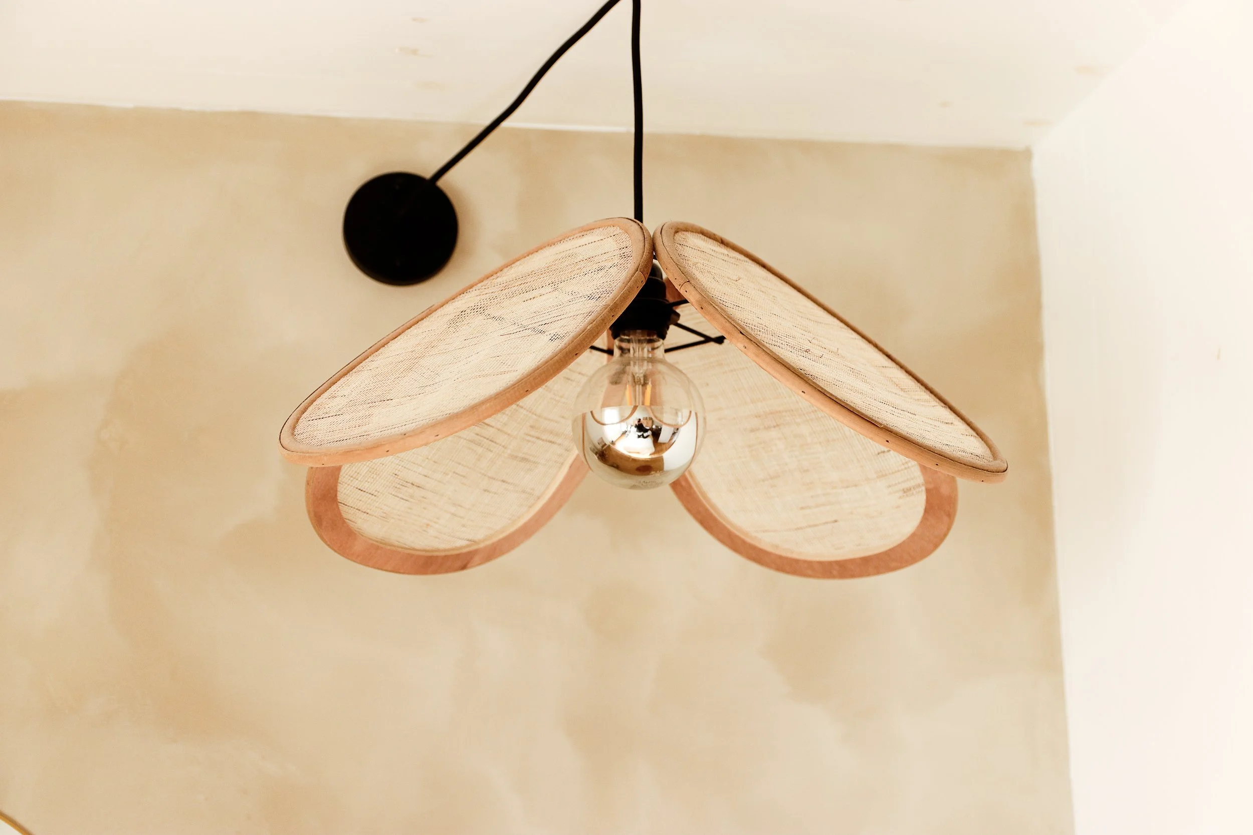 Suspension bois et cannage devant mur à la chaux beige Ressource