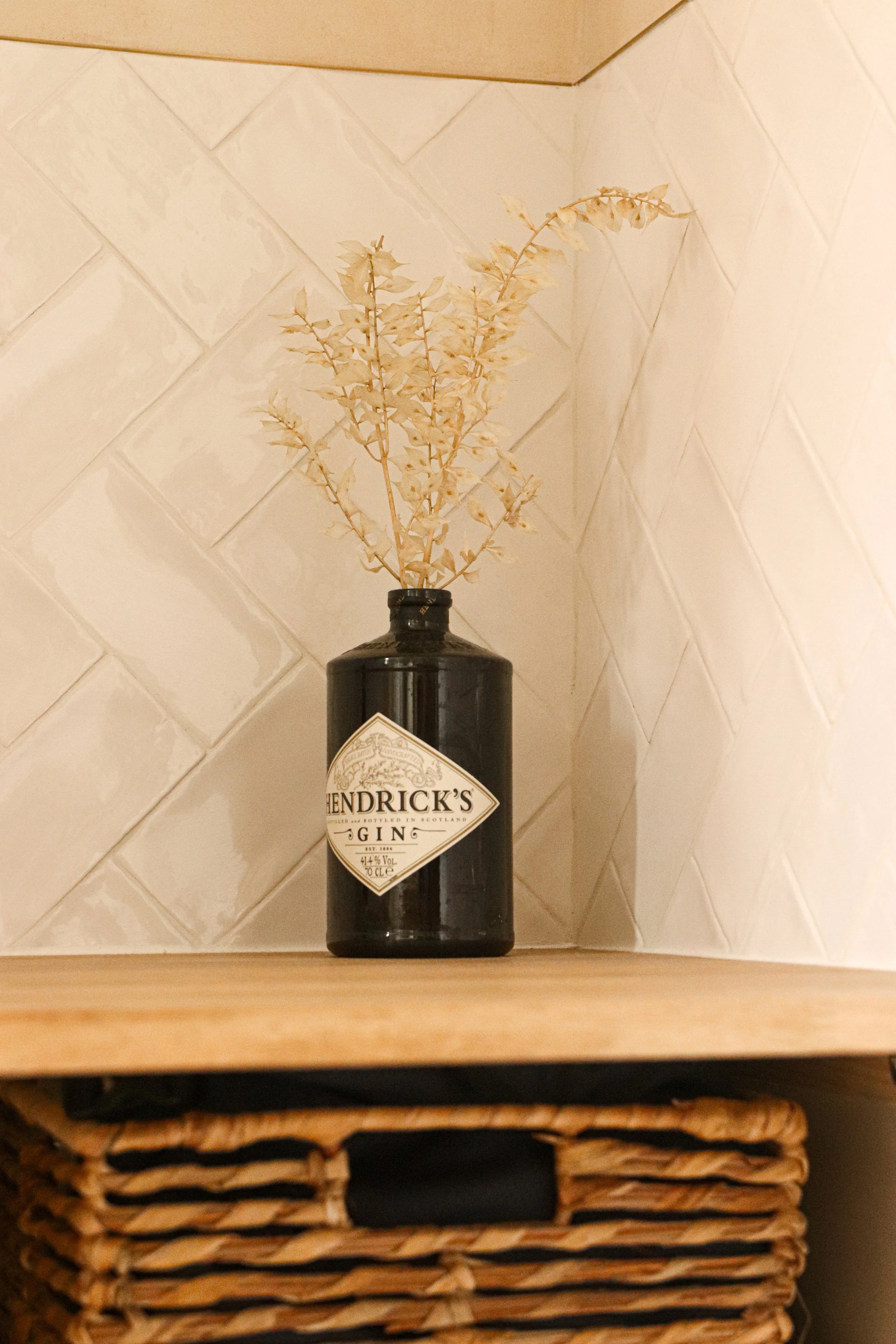 Détail déco salle de bain, fleurs séchées sur tablette en bois avec panière jute - ambiance chaleureuse et naturelle