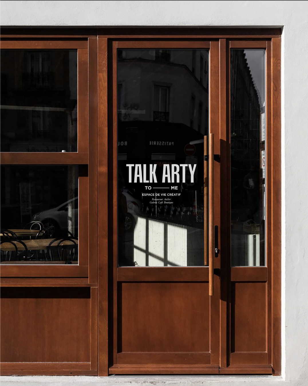 Façade en bois d'un restaurant avec une porte vitrée portant l'inscription "TALK ARTY".