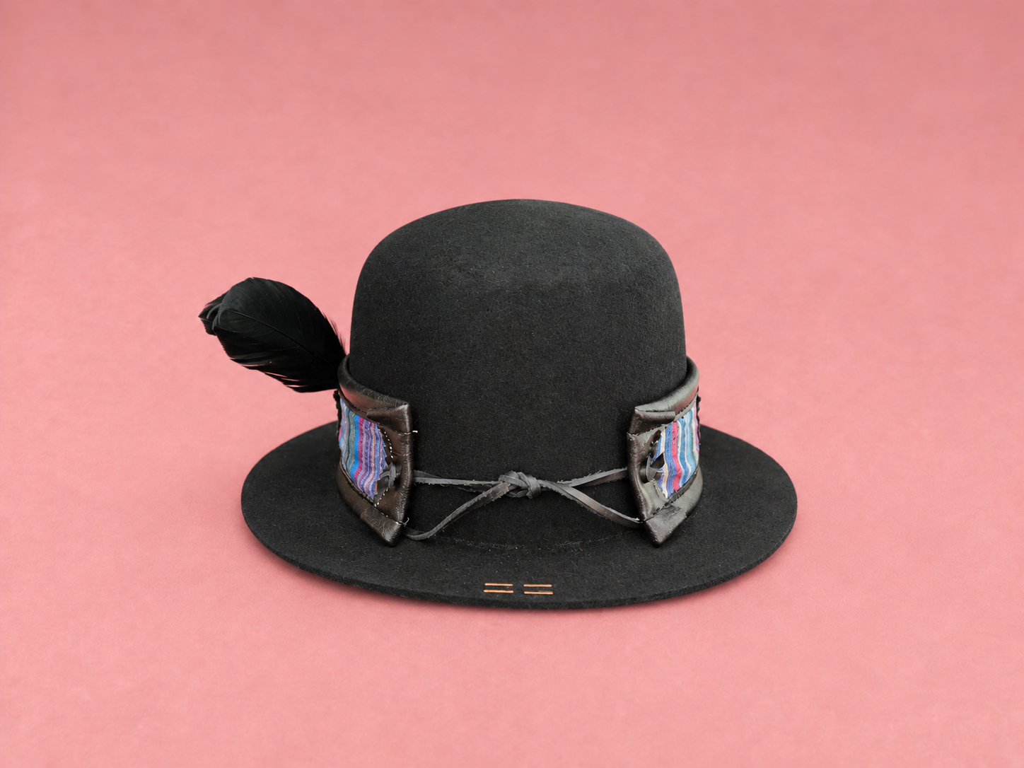 Black feathered hat on blush pink.png