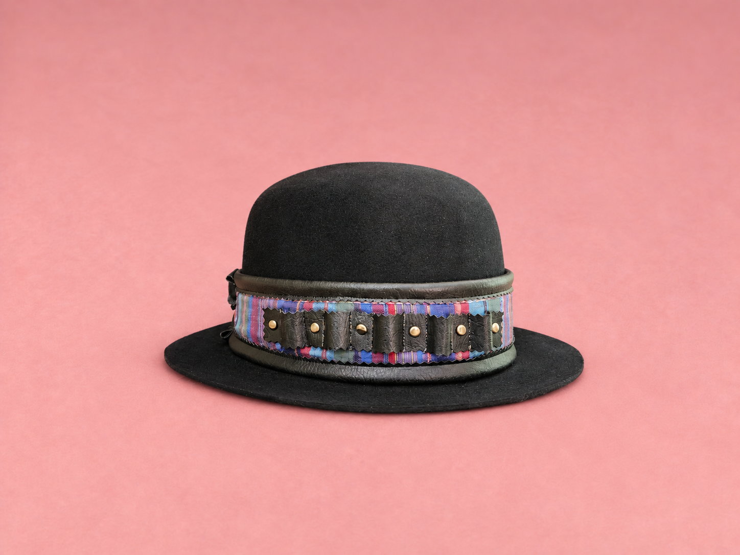 Black bowler hat on pink canvas.png