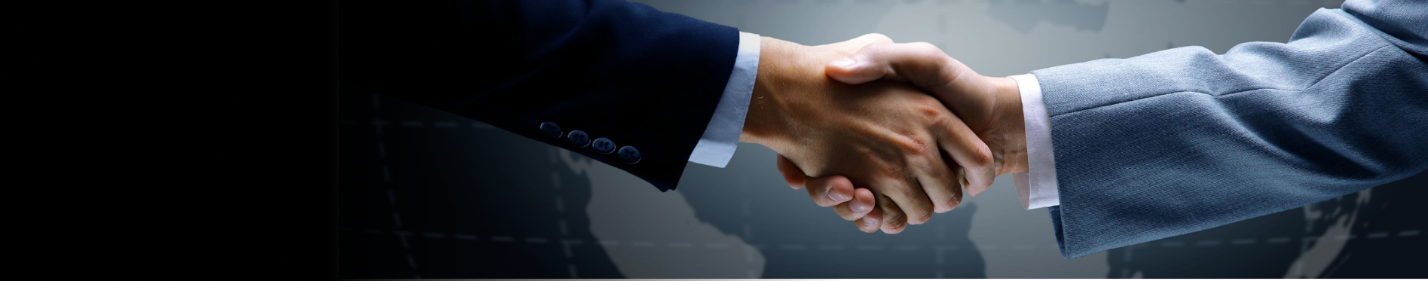 Close-up of two people in business suits shaking hands.