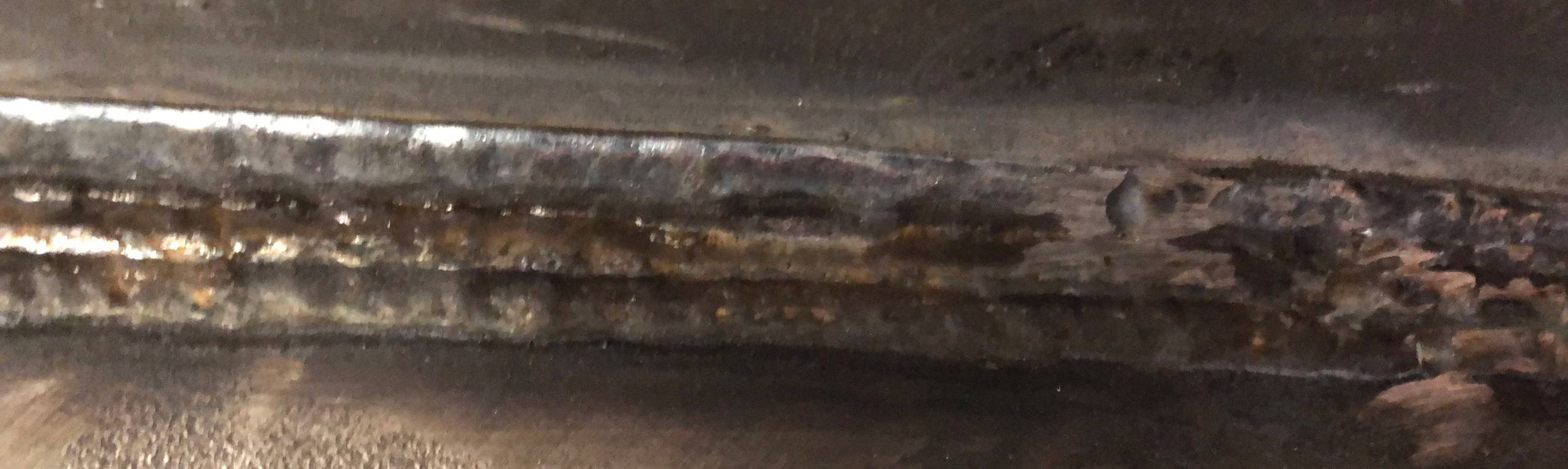 Close-up of a rusted and corroded metal surface with rough textures.