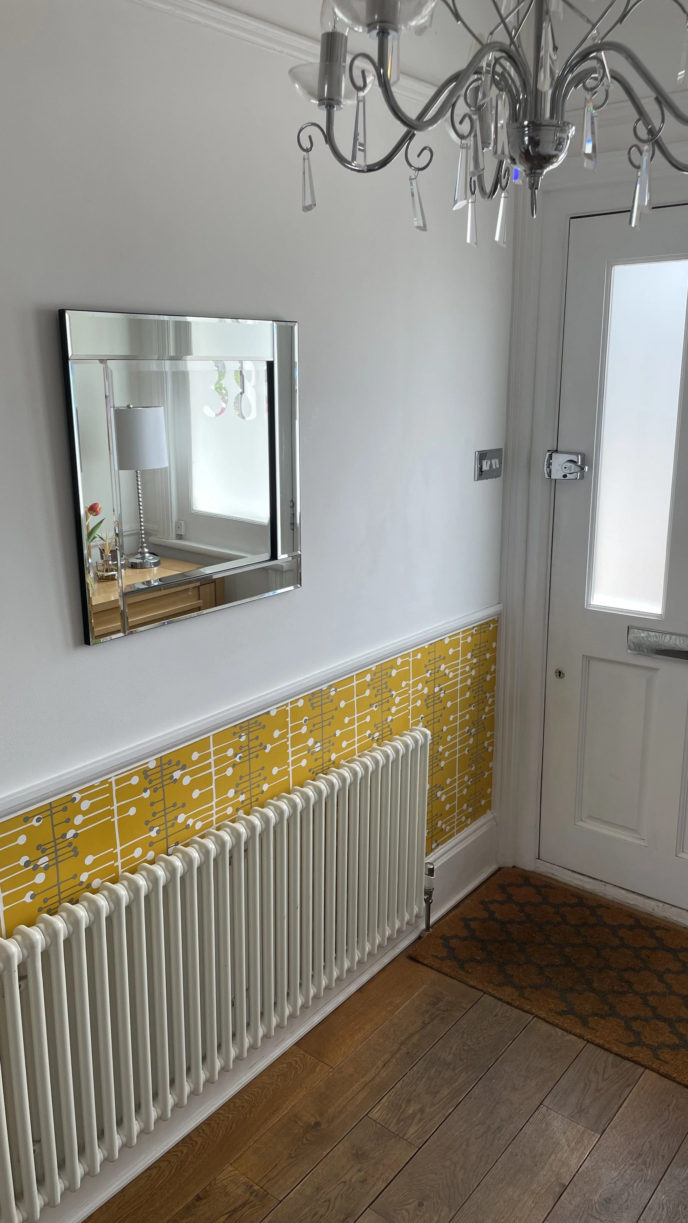 Statement hallway with mid-century patterned wall panel and pristine white trim.