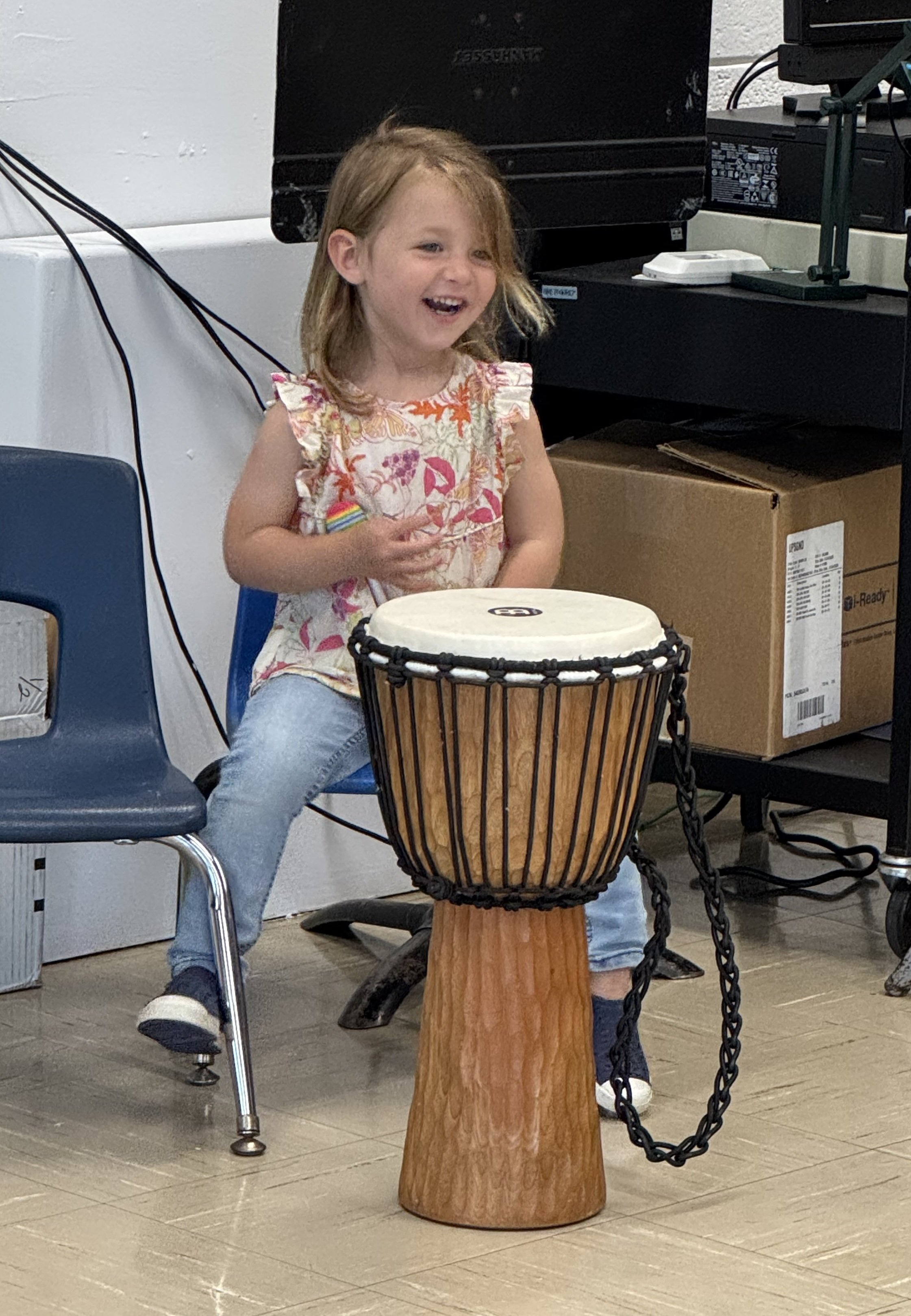 young girl playing djembe drum at laura cerrano's drum circle for school program long island ny