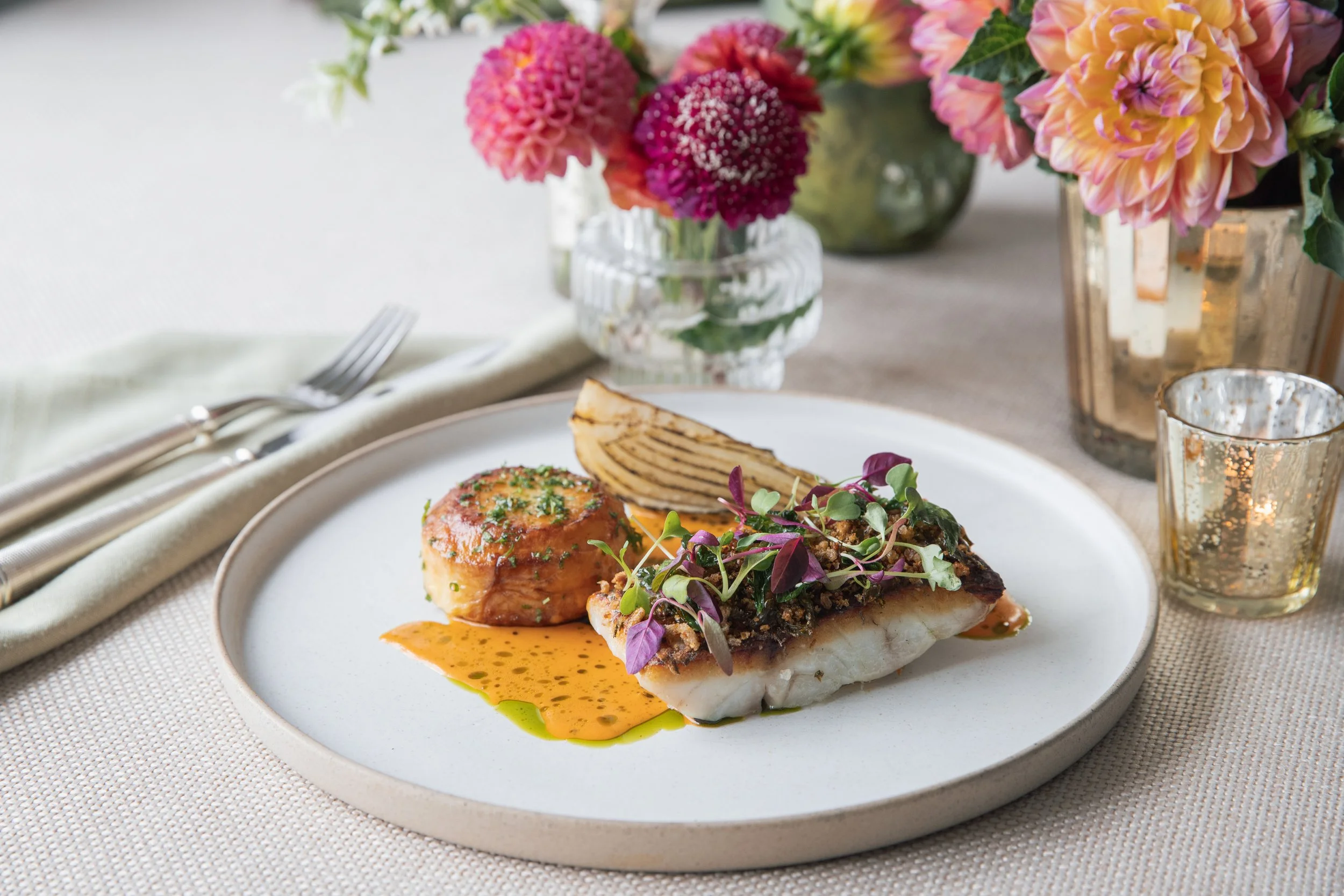 Stone bass and potato with fennel on plate with flowers