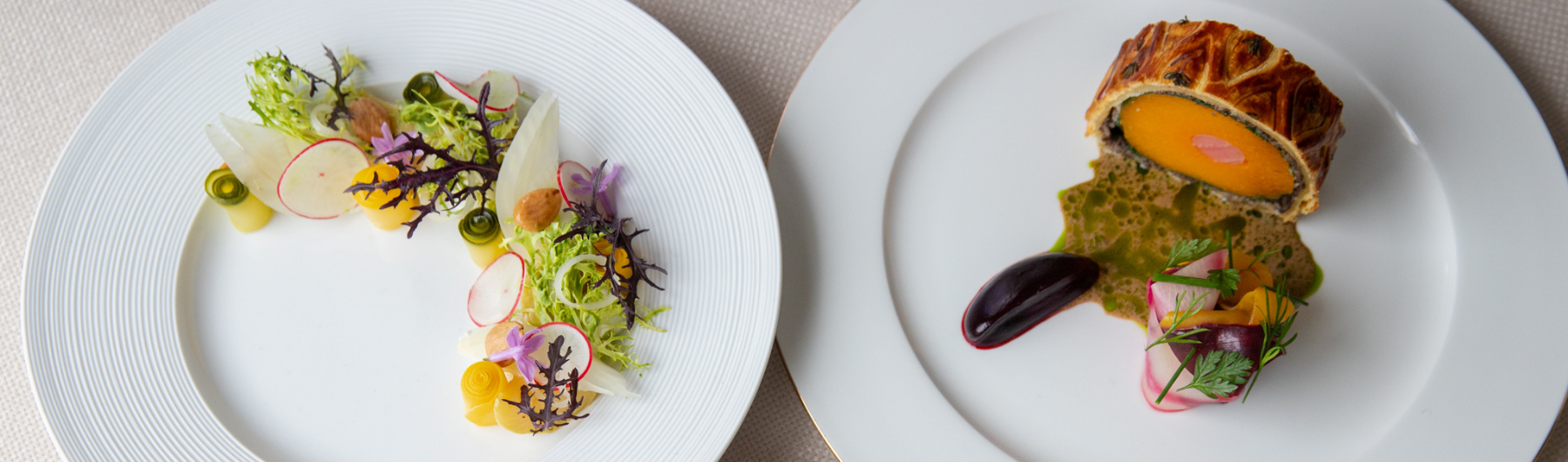 A plate of Spring Garden seasonal vegetables with fresh green tones, served next to a slice of Summer Squash and Candy Beetroot Wellington wrapped in golden pastry.