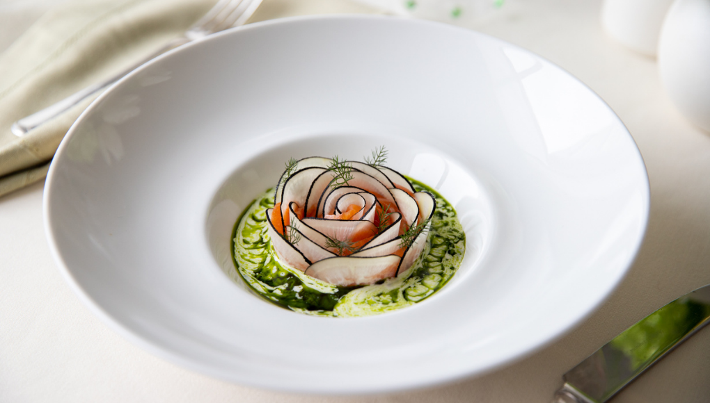 Thin slices of cured chalkstream trout arranged on a plate as a starter course.