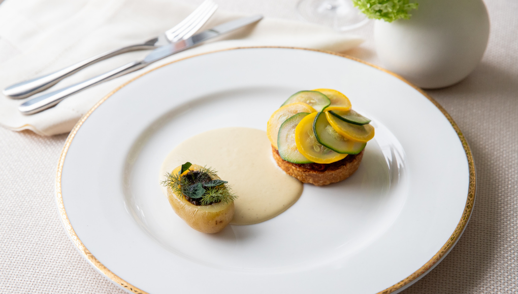 Globe artichoke and ratatouille tart, a vegan main course served on a neatly presented plate.