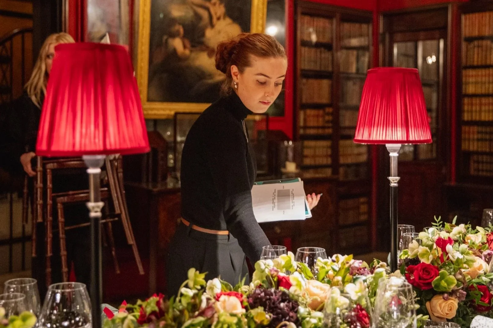 A young woman with shoulder-length dark hair smiling outdoors in a park, wearing a light-colored jacket.