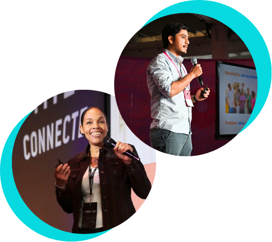 Two speakers on stage giving a presentation, one man and one woman, with a large screen in the background.