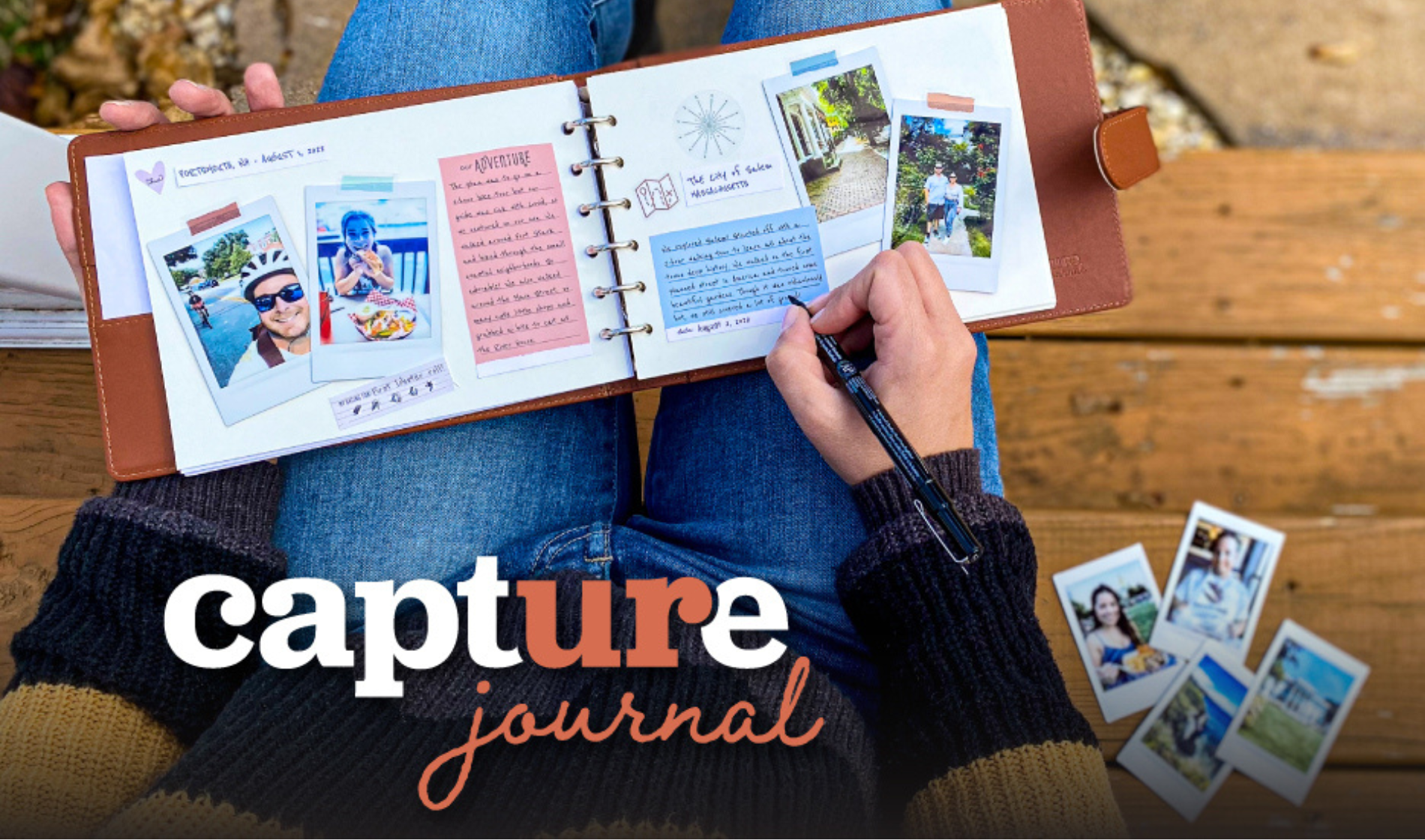 A person sitting on a wooden bench, wearing a multicolored sweater and blue jeans, writing in a brown leather-bound capture journal with a black pen. The journal is open to pages filled with photos, handwritten notes, and colorful paper accents. Several printed photographs are scattered on the bench next to them.
