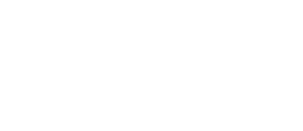 A person sitting on a boat with a dog, both wearing life jackets, on a body of water with trees in the background.