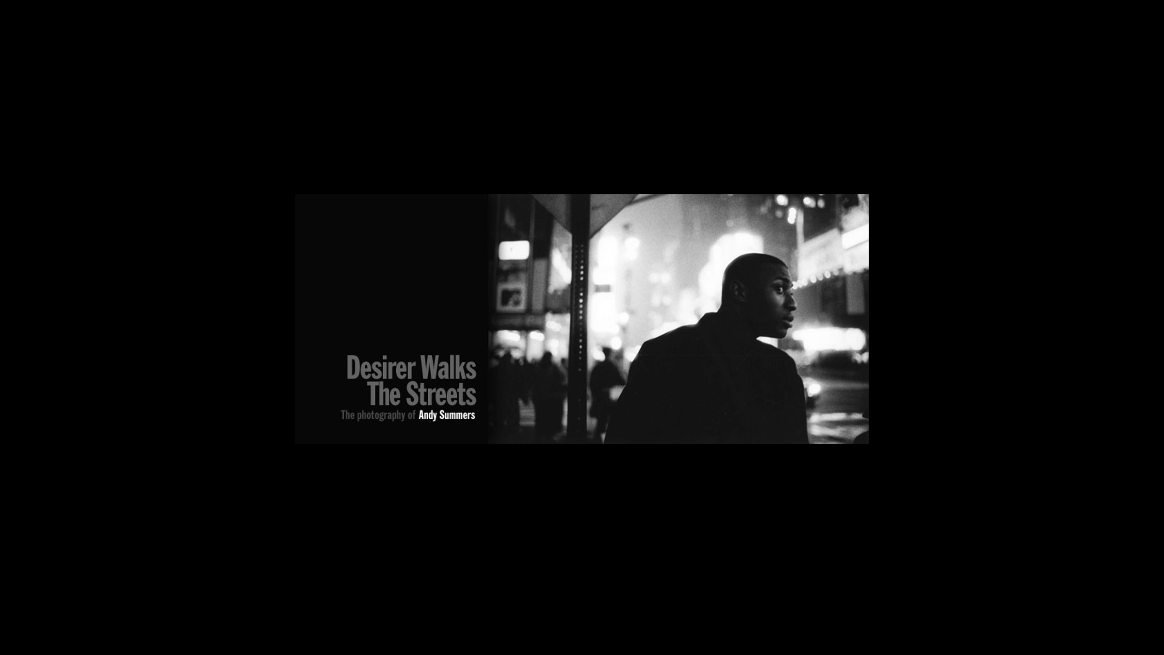 Black and white photo of a man on a city street at night, looking to the right, with bright lights and signs in the background. There is text that says 'Desirer Walks The Streets' and 'The photography of Andy Summers'.