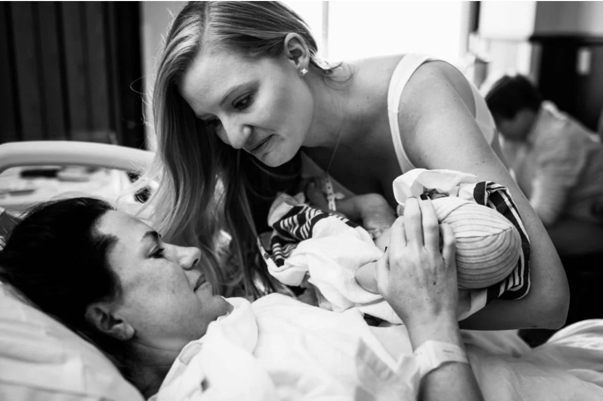 Surrogate and Intended Mom share a special moment with newborn baby