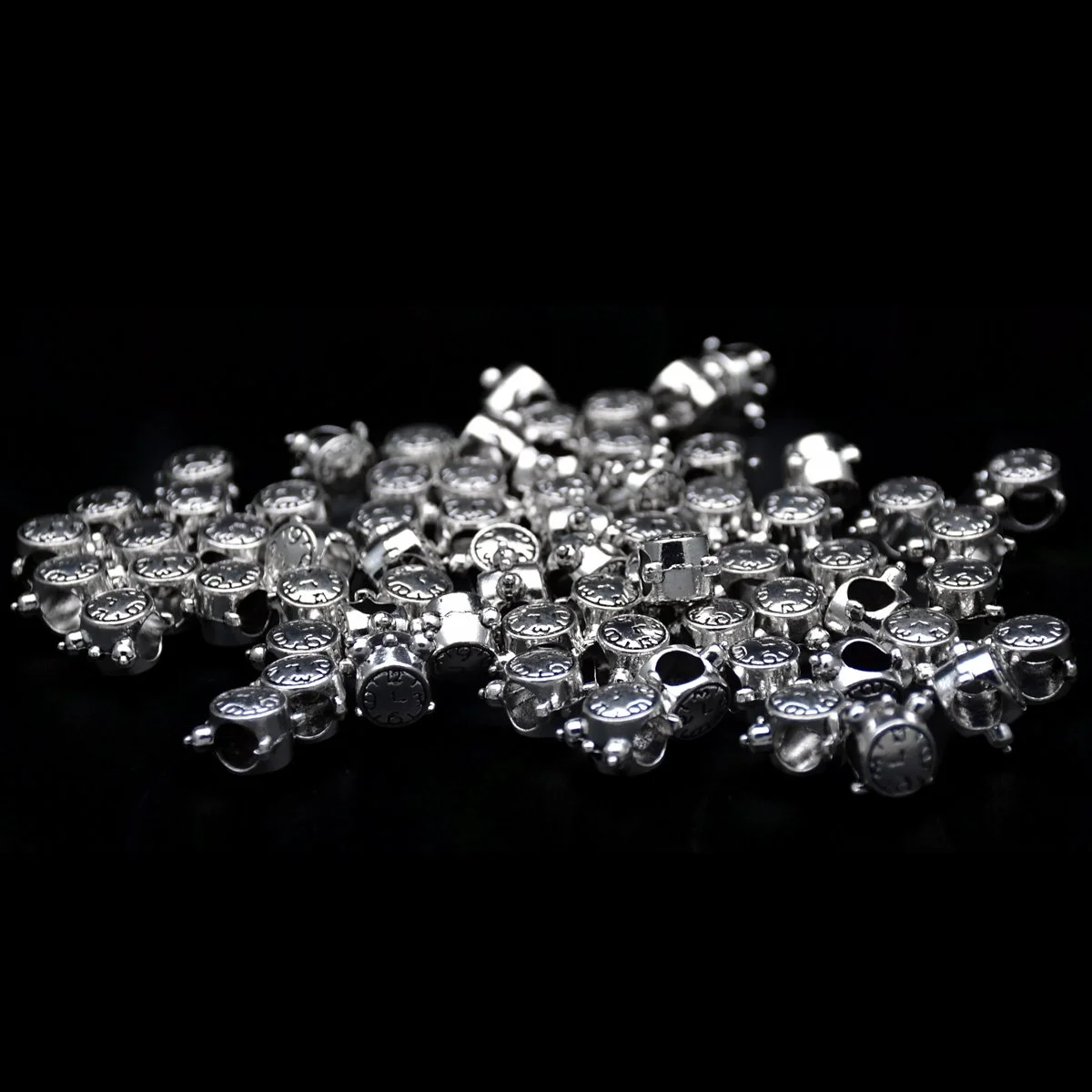 bulk of Alarm shape big hole pandora bracelet beads scattering around in a black background