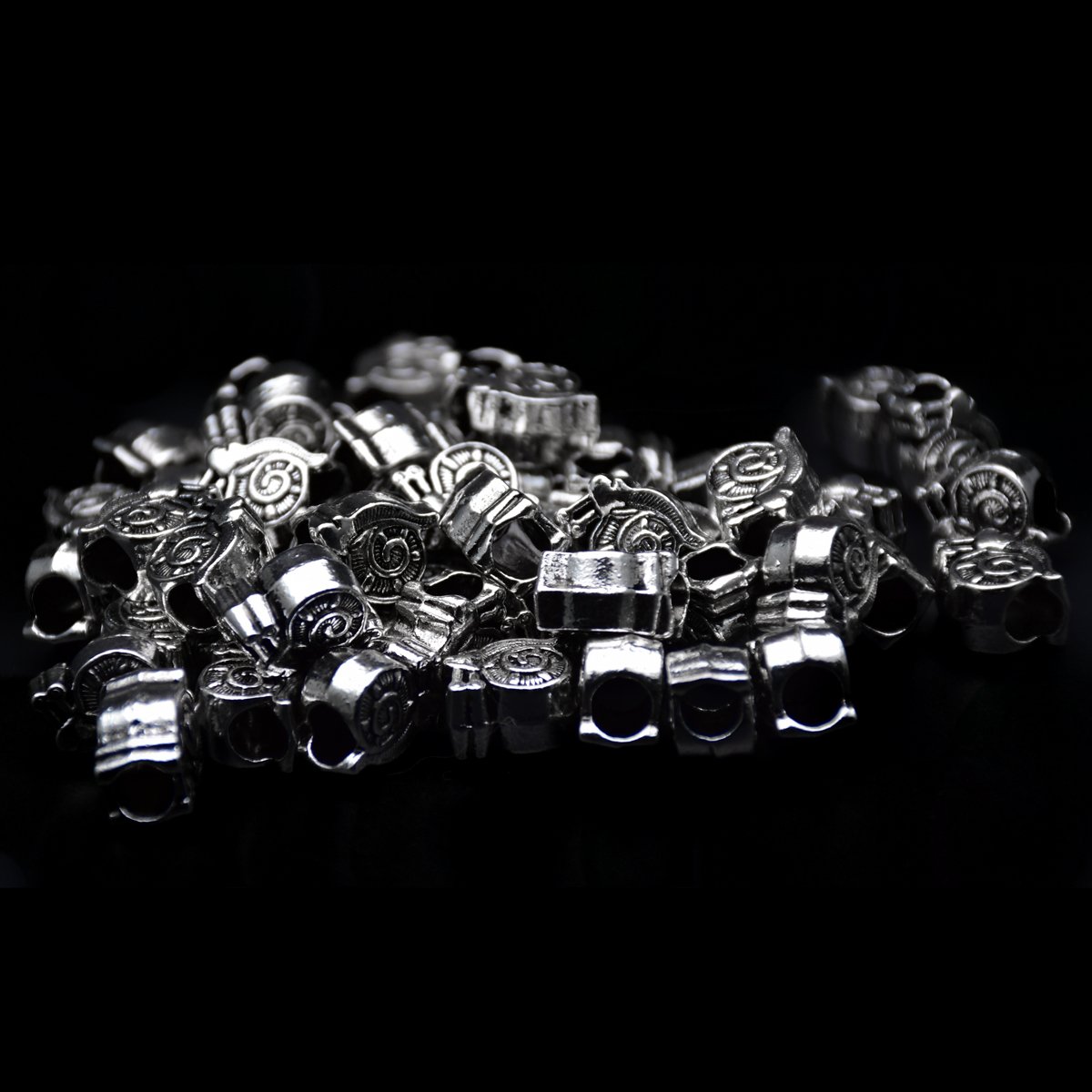 antique Tibetan silver big hole pandora beads in snails shape scattering around in a black background